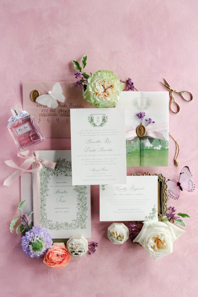 a wedding invitation suite styled on a pink background