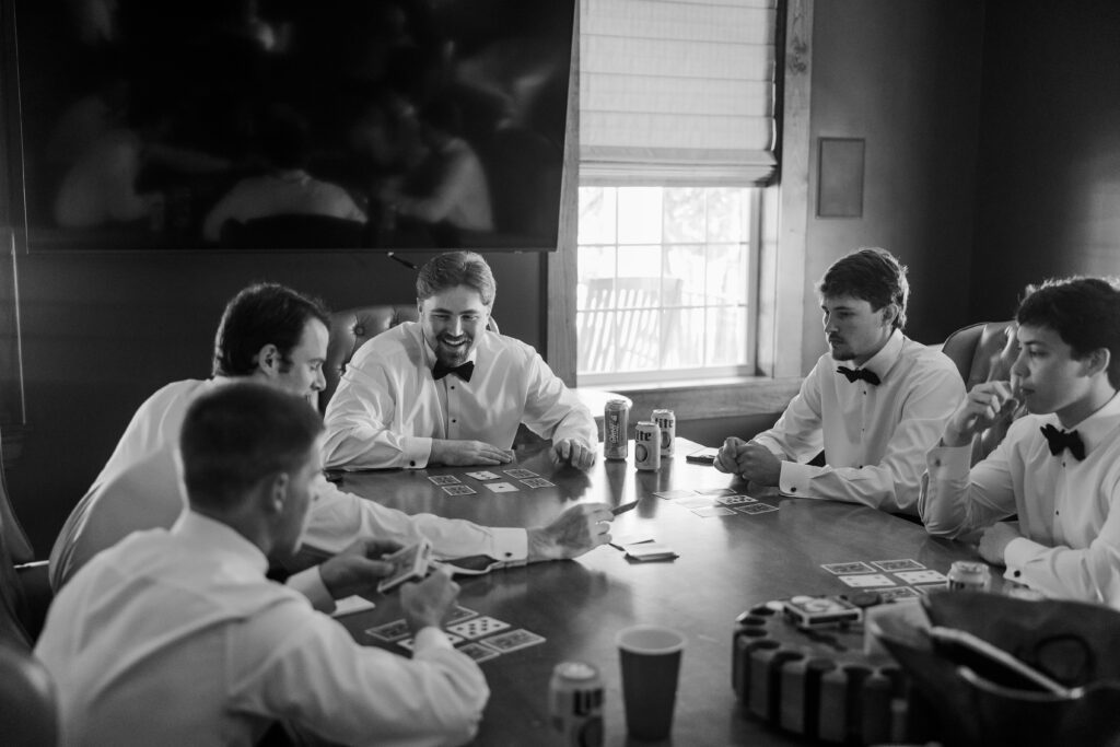 Lake and his groomsmen play cards while getting ready for their Loxley, Alabama wedding