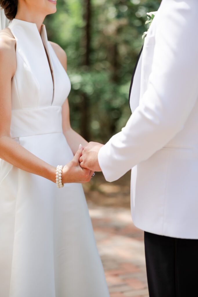 Grace and Lake hold hands during their Steelwood Country Club wedding first look