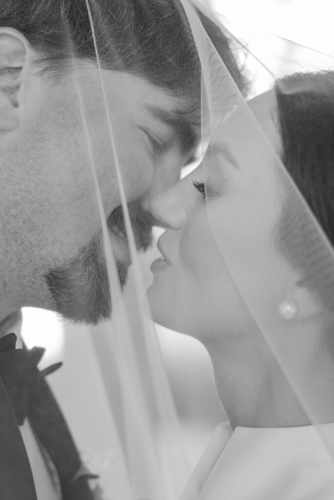 Grace and Lake kiss beneath her wedding veil at Steelwood Country Club