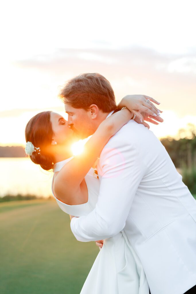Grace and Lake kiss at sunset during their Steelwood Country Club wedding