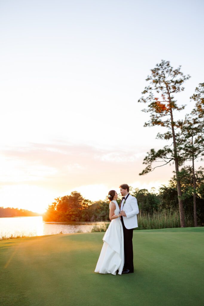 Grace and Lake pose together by the lake at sunset