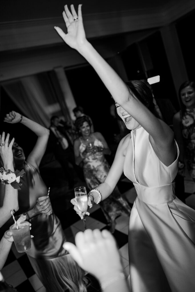 Grace dances with a champagne glass at her Steelwood Country Club reception