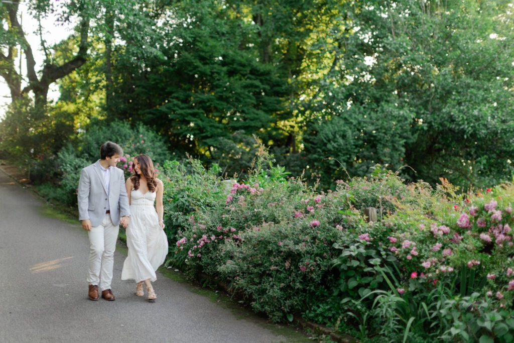Emily & Brody walk hand in hand on a paved path at the Birmingham Botanical Gardens.