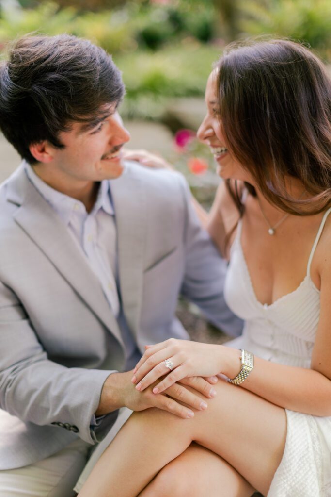 Emily and Brody laugh together during their Birmingham Botanical Gardens engagement session.