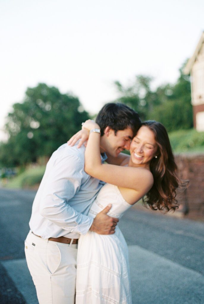 Couple embracing and laughing together during an outdoor engagement session in Birmingham.